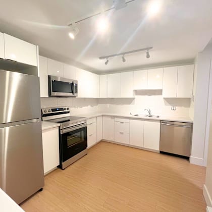 a kitchen with a refrigerator, oven, microwave, and sink.