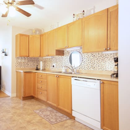 a kitchen with wooden cabinets and a white dishwasher.