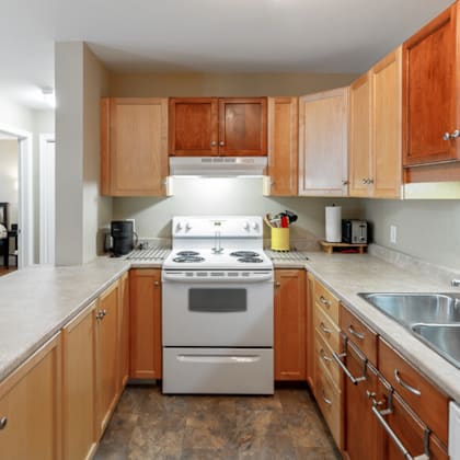 a kitchen with a stove top oven and wooden cabinets.