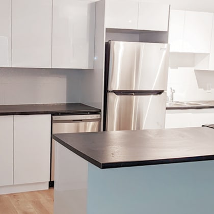 a kitchen with a stainless steel refrigerator and white cabinets.