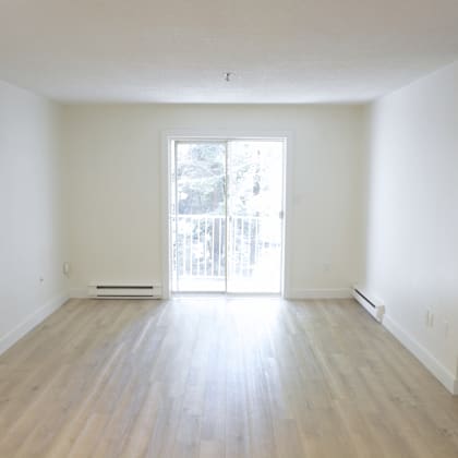 a room with a sliding glass door leading to a balcony.