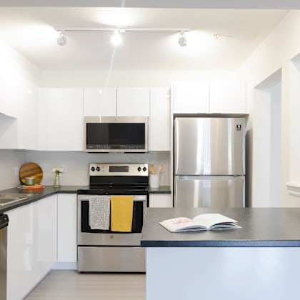 a modern kitchen with a stainless steel refrigerator and a black oven.