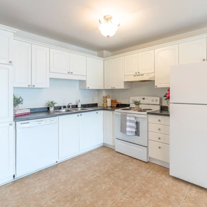 a kitchen with white cabinets and appliances.