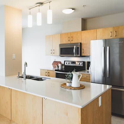 a modern kitchen with wooden cabinets and stainless steel appliances.