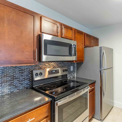 a kitchen with a stove, oven, microwave, and refrigerator.