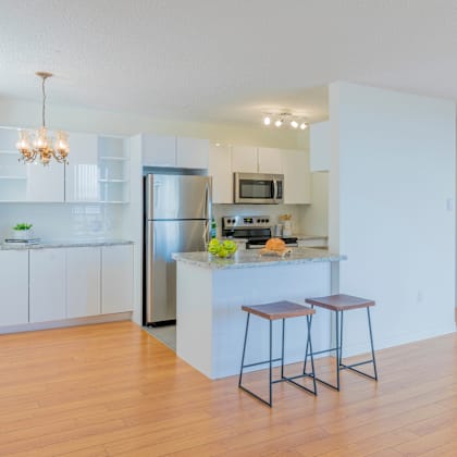 a kitchen with white cabinets and a wooden island.
