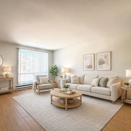 a living room with a white couch, a wooden coffee table, and a window with blinds.