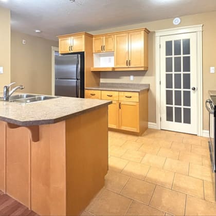 a kitchen with wooden cabinets and a black refrigerator.