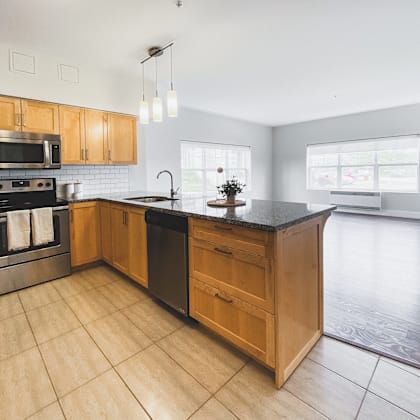 a kitchen with wooden cabinets and a black countertop.