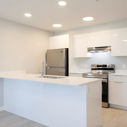 a modern kitchen with white cabinets and appliances.