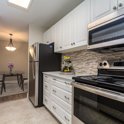 a kitchen with black appliances and white cabinets.