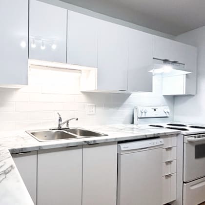 a white kitchen with a sink and stove.