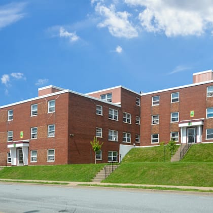 a red brick building with a green sign on the front.