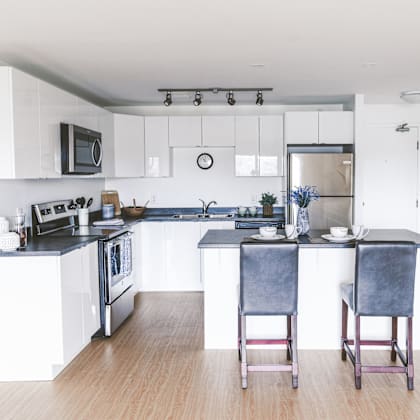a kitchen with a black countertop and white cabinets.