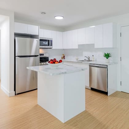 a modern kitchen with a white island in the middle.