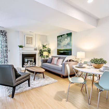 a modern living room with a grey sofa, a black chair, a coffee table, and a fireplace.