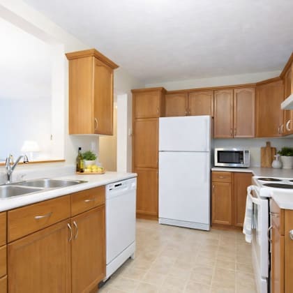 a kitchen with wooden cabinets and white appliances.