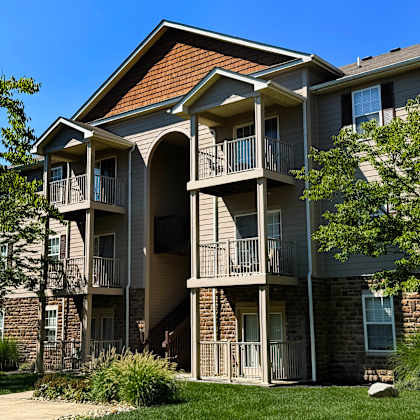 a large apartment building with a balcony and a patio.