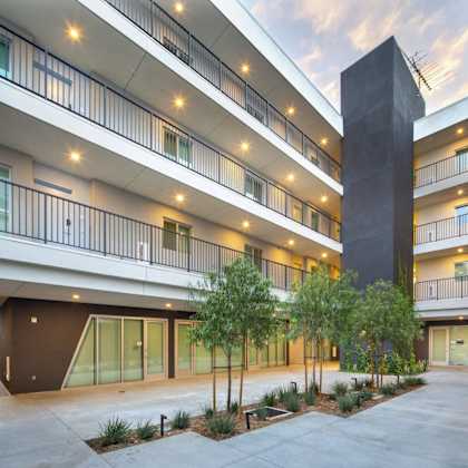 a modern building with a courtyard and a tall column.