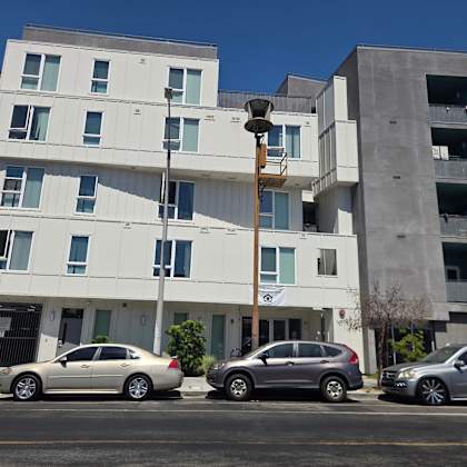 a modern building with three cars parked in front.