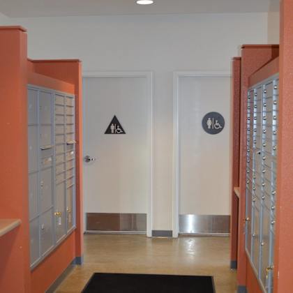 a hallway with a black carpet and a white door with a wheelchair symbol.