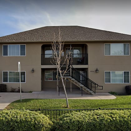 a two-story building with a brown roof and beige walls.