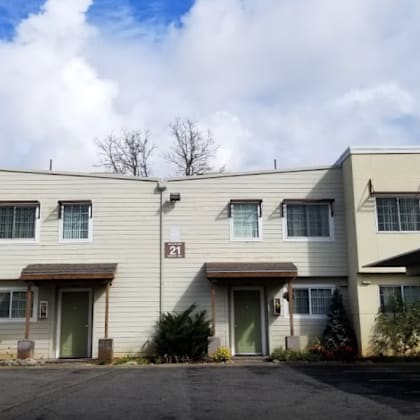 apartment building with cars parked in front.