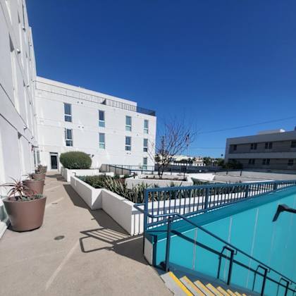 a pool area with a white building in the background.