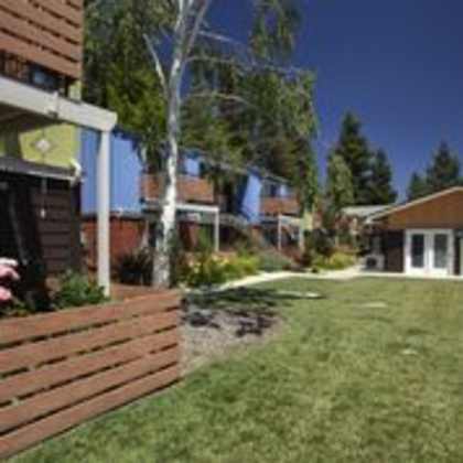 a grassy area in front of a building with a bench.