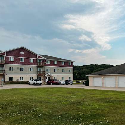 an apartment building with a green lawn in front of it