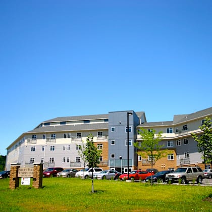 a parking lot in front of a multi-story apartment building.