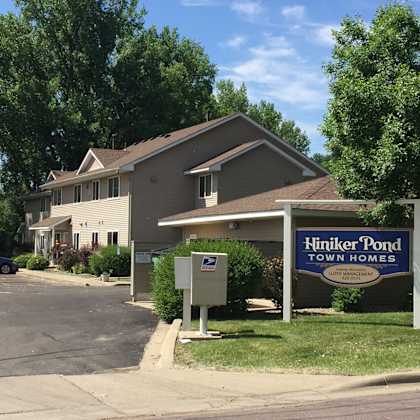 a sign for hiniker pond town homes is in front of a building.