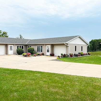 a house with a garage and a flag on the lawn.
