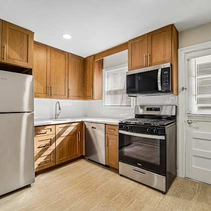 a kitchen with wooden cabinets and stainless steel appliances.