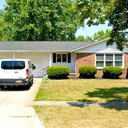 a white van is parked in front of a house.