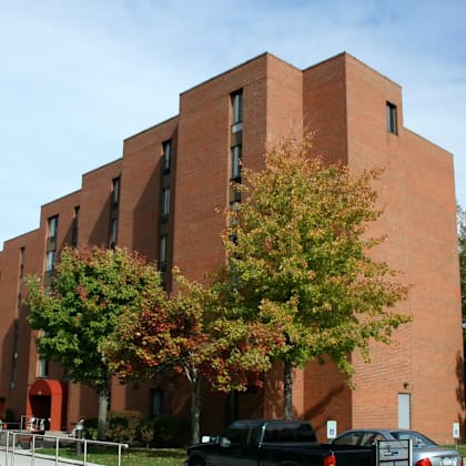 a large red brick building with trees in front.