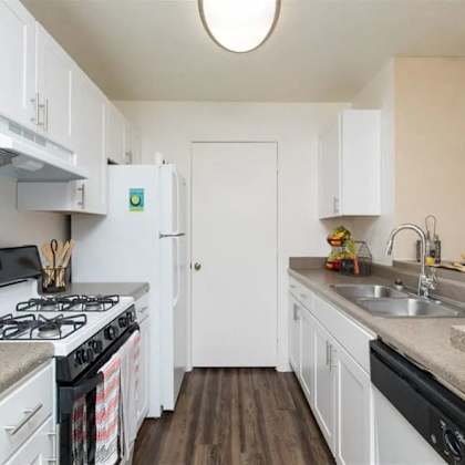 a kitchen with a stove top oven next to a sink