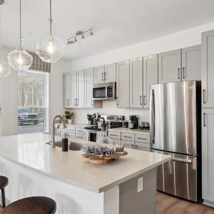 a modern kitchen with a white countertop and stainless steel appliances at vintage raleigh west apartments, raleigh, nc