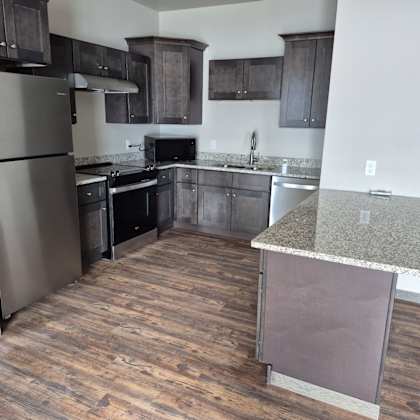 a kitchen with a refrigerator, oven, and microwave.