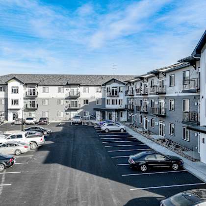 an aerial view of a parking lot in front of apartment buildings