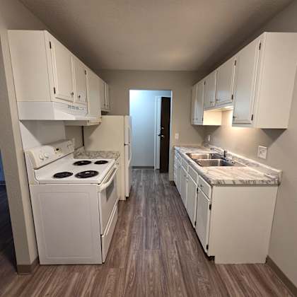 a kitchen with white cabinets and a stove top oven.