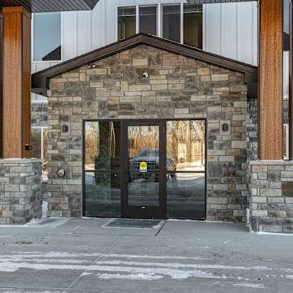 a building with a stone facade and a black door.
