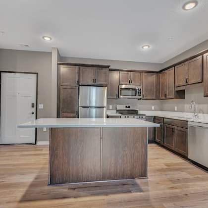 a modern kitchen with wooden cabinets and a central island.