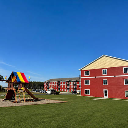 a playground with a slide and a building in the background.