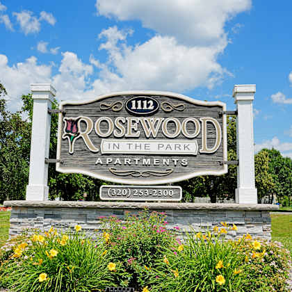 a sign for rosewood apartments is displayed in front of a building.