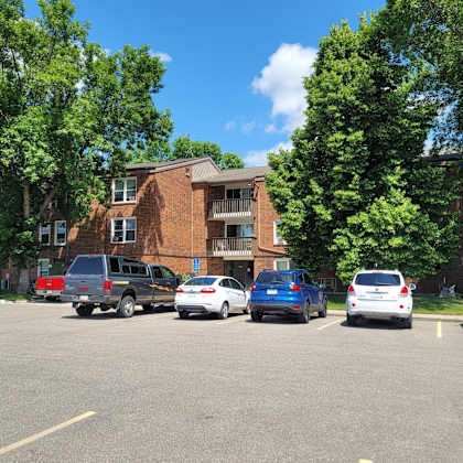 a parking lot with cars and a building in the background.