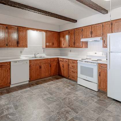 a kitchen with wooden cabinets and white appliances.