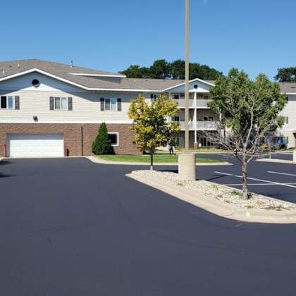 a parking lot in front of a building with a clear blue sky.
