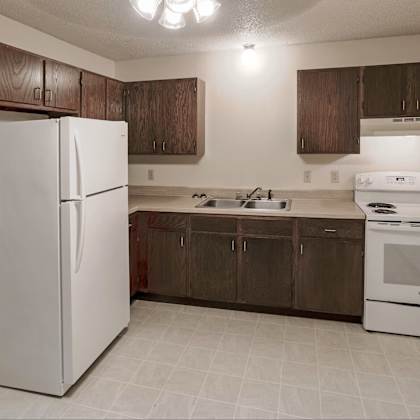 a white refrigerator is in a kitchen with brown cabinets.