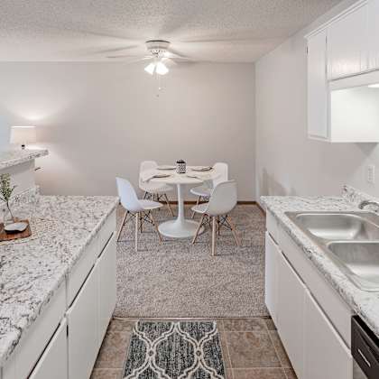 a kitchen with a marble countertop and white cabinets.